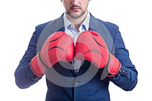 Close up businessman in suit with boxing gloves stands ready in a fighting stance, punching his fists. Business person self