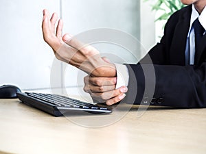 Young Asian businessman pain while using notebook computer in office