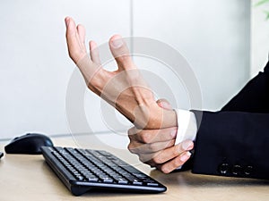 Young Asian businessman pain while using notebook computer in office