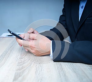 Close-up of a businessman in a suit using a smartphone to communicate with the client View marketing and social networking on the