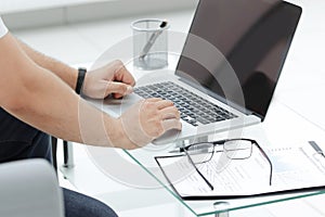 Close up. businessman typing on a laptop