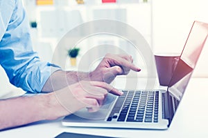 Close up of businessman typing at laptop