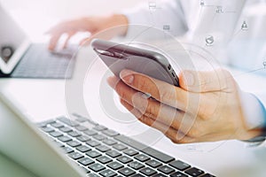 close up of businessman using mobile phone and laptop computer o