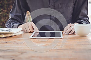 Close up businessman using tablet working in coffee shop