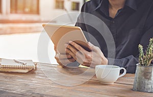 Close up businessman using tablet working in coffee shop.