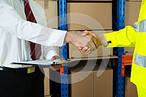 Close-up Of Businessman And Warehouse Worker Shaking Hands