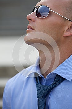 Close-up of a businessman wearing sunglasses and looking up