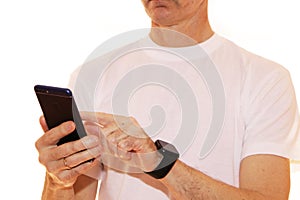 Close-up - businessman in a white t-shirt holds a smartphone in his hand