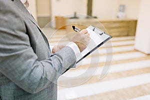 Close-up businessman writing on a blurred background. Office conference concept. Copy space.