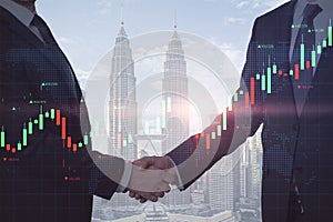 Close up of businessmen shaking hands on abstract blurry city background with glowing forex chart and map. Teamwork, trade and