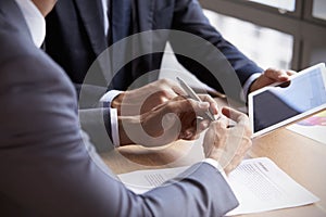 Close Up Of Businessmen Using Digital Tablet In Meeting