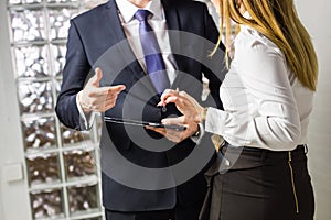 Close-up of Businesspeople With Digital Tablet Sitting In Modern Office