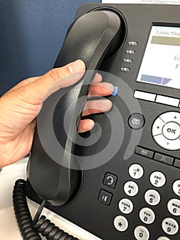Close up businesspeople left hand hold headset of landline IP phone in office for conference meeting