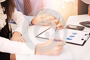 Close-up of businesspeople working and pointing on document