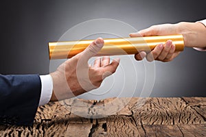 Close-up Of A Businessperson Passing Baton