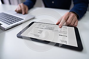 Businessman Working With Invoice On Digital Tablet