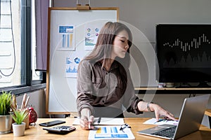 Close up of businesswoman or accountant hand holding pen working on calculator to calculate business data, accountancy