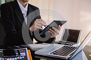 Close up of businesswoman or accountant hand holding pen working on calculator to calculate .on desk about cost