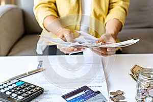 Close up of Businesswoman checking bills and calculating monthly expense at her desk. Home saving concept. Financial and