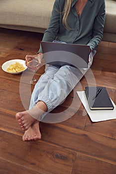 Close Up Of Businesswoman At End Of Day With Wine In Loungewear And Suit On Laptop Working At Home photo