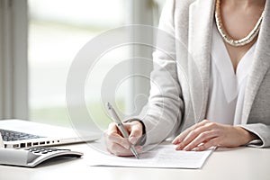 Close-up of businesswoman fill a form.