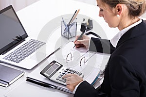 Businesswoman Hand Calculating Invoice Using Calculator