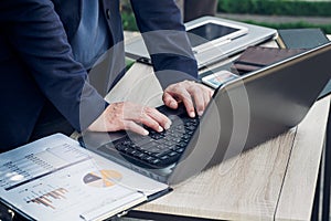 Close up businesswoman hand typing on laptop computer on table,working outside office with networking technology,tone filtered