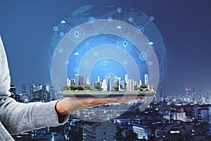 Close up of businesswoman hands holding tablet with abstract glowing connections globe on city background