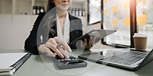 Close-up of businesswoman hands using a calculator to check company finances and earnings and budget. Business woman