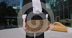 Close up businesswoman holding poster cardboard with need job jobless message. Global unemployment.