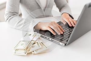 Close up of businesswoman with laptop and money