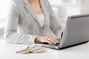 Close up of businesswoman with laptop and money