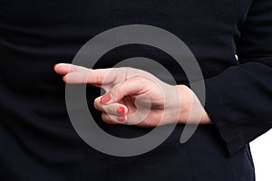 Close-up of businesswoman making bad luck gesture behind back