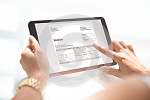 Businesswoman Checking Invoice On Digital Tablet photo