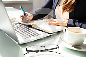 Close-up Of A Businesswoman`s Hand Writing Note In Diary