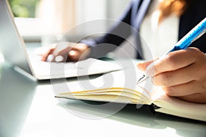 Close-up Of A Businesswoman`s Hand Writing Note In Diary