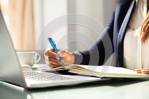 Close-up Of A Businesswoman`s Hand Writing Note In Diary