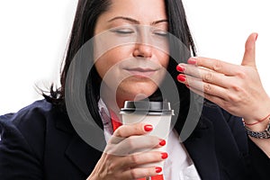 Close-up of businesswoman smelling coffee aroma from paper cup