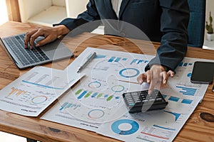 Close up businesswoman using calculator for do math finance on wooden desk in office and business working background