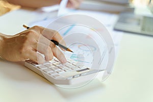 Close up of businesswoman working on calculator to calculate business data the financial report on white table.