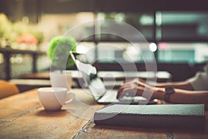 Close up of businesswoman working at office with laptop. Mobile phone and Marketing summary report graph data documents on desk.