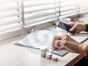 Close up on businesswomen hand holding a coins with a sheet on t