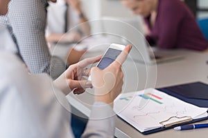 Close up of busineswoman hands using smart phone on meeting