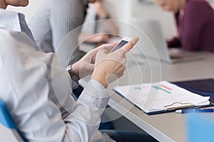 Close up of busineswoman hands using smart phone on meeting