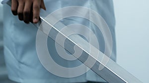 Close up of busy black doctor going down staircase at hospital, holding handrail, slow motion