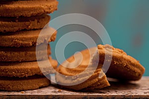 Close up of butter cookies/biscuits on wooden board with teal green rustic background