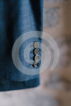 Close-up of buttons on the sleeve of a men`s blue jacket, shallow depth of field.