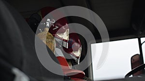 Close-up of a cabin window of a red and white large fire truck with a mirror in the foreground