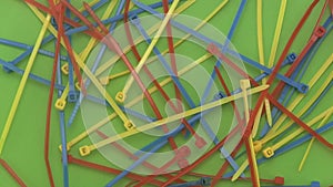 Close up of cable ties or ny-lock rotating on a green background.