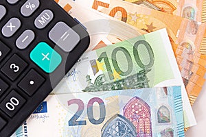 Close-up of calculator on Euro banknotes. Euro money bills to pay. Finances and budget concept. Tax and money